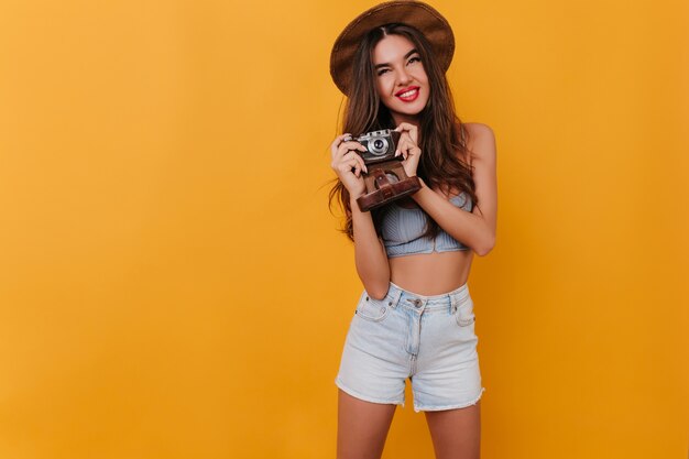 Ecstatic brunette female photographer posing with cute smile