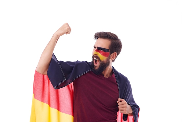 Foto gratuita tifoso estatico con la bandiera della germania che acclamava
