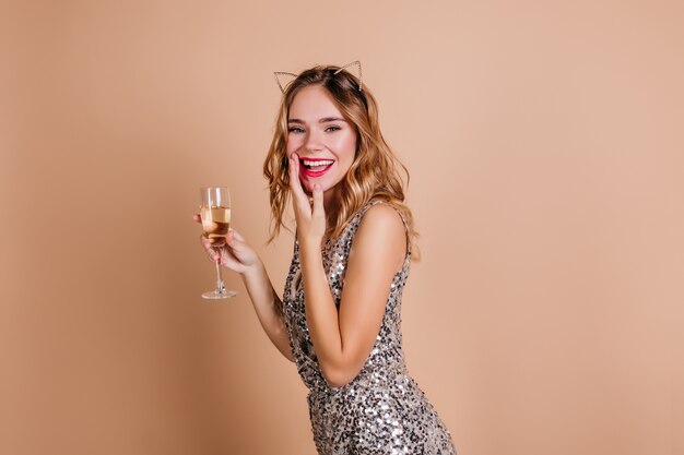 Free photo ecstatic slim white woman covers mouth with hand, laughing at new year party