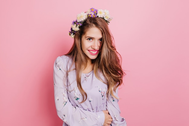 Free photo ecstatic woman with light-brown hair expressing positive emotions while posing in flower wreath