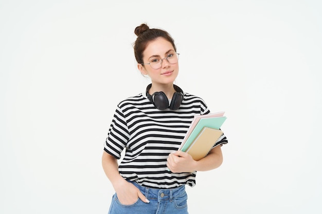 Free photo education concept smiling brunette girl student in casual clothes holds her books study material