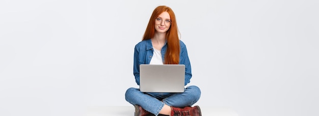 Free photo education modern lifestyle and college concept attractive carefree redhead female student sitting wi