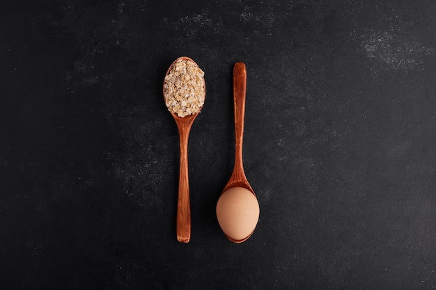 Egg and flour on wooden spoons in crossing style. 