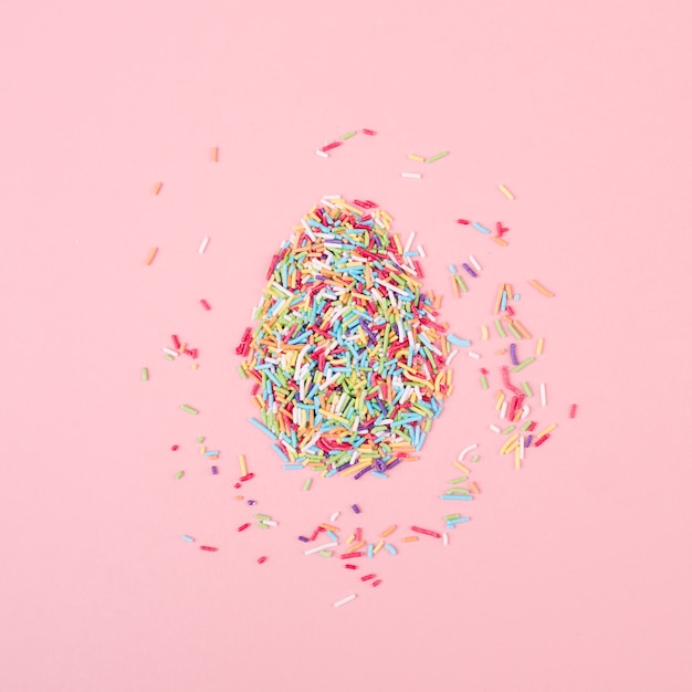 Egg made of colorful sprinkles on table