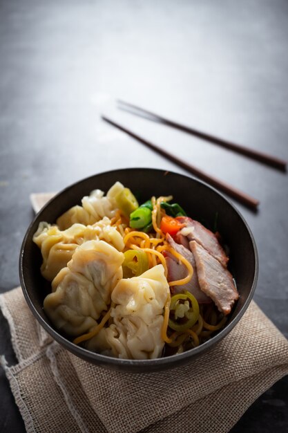 赤いローストポークとワンタンのテーブルの上に卵麺。