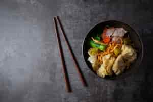 Free photo egg noodle with red roasted pork and wonton on table.