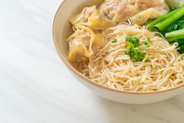 Egg noodles with pork wonton soup or pork dumplings soup and vegetable - asian food style