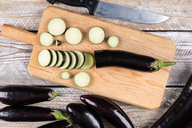 Eggplant and chopped one on a cutting board and wooden 