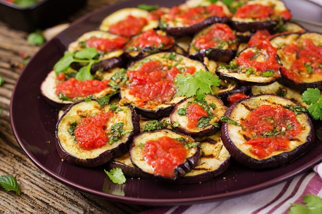 eggplant grilled with tomato sauce, garlic, cilantro and mint. vegan food. grilled aubergine.