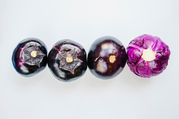 Eggplant and purple cabbage arranged on white background