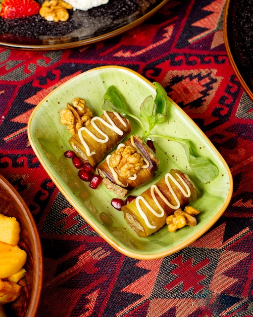 Eggplant rolls served with walnuts and pomegranate