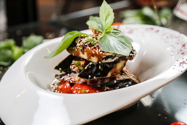 Eggplant with herbs topped with sesame seed close-up view