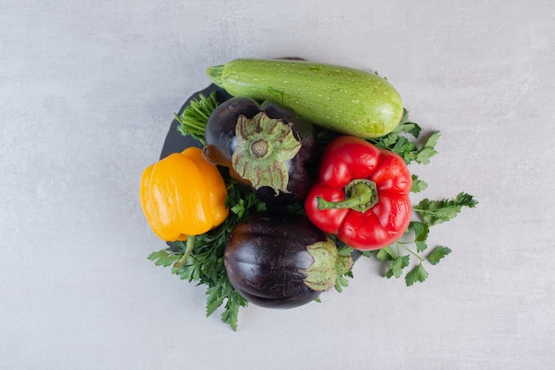 Free photo eggplants, bell peppers and parsley on wooden piece. high quality photo