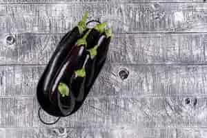 Free photo eggplants in a pot on a gray wooden . top view. space for text