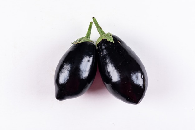 Eggplants side by side on a white . top view.