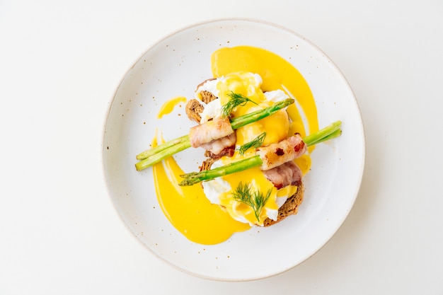 Eggs benedict with bacon twist asparagus