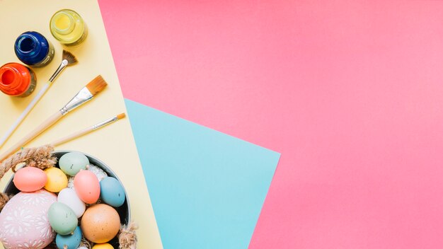 Eggs and brushes on colorful background