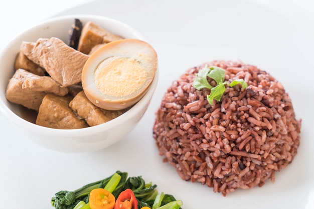 Free photo eggs and chicken in brown sauce with berry rice