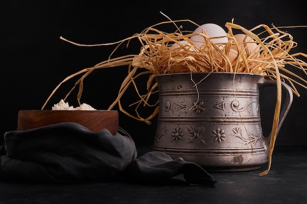 Eggs on the dry grass with a cup of flour. 