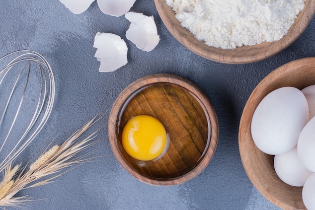 Foto gratuita uova e tuorlo d'uovo come ingredienti per fare la pasta