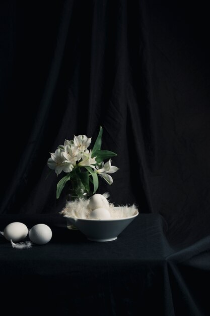 Eggs and feathers near bunch of flowers