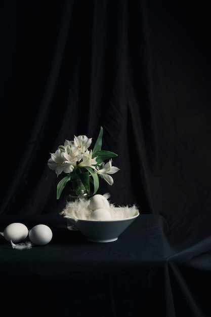 Eggs and feathers near bunch of flowers