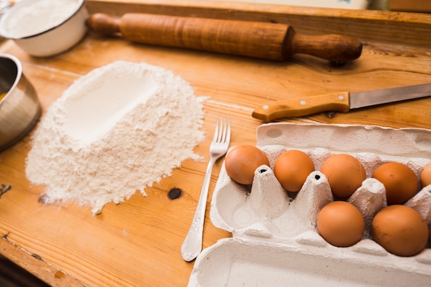 木製の卓上にある卵と小麦粉