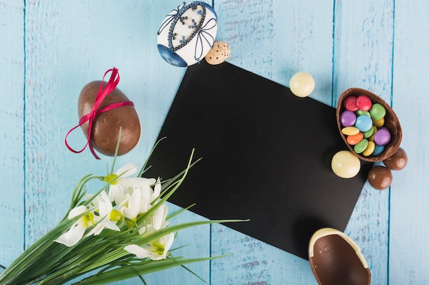 Foto gratuita uova e fiori con carta nera