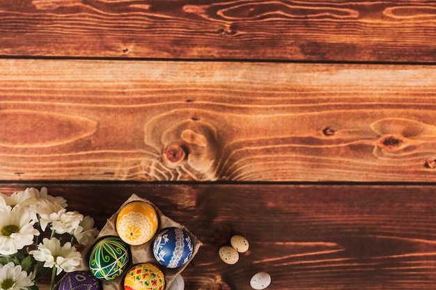 Eggs and flowers on wooden tabletop