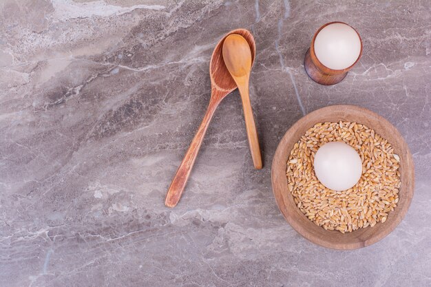 Eggs isolated in a wooden cup on the stone