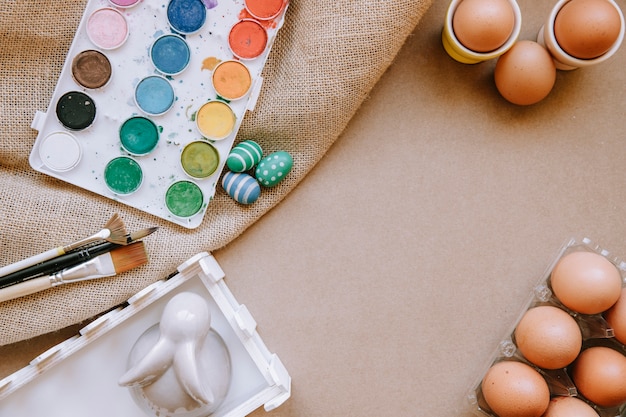 Яйца и краски на столе с холстом