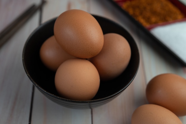 Eggs placed in a cup on a wooden floor.