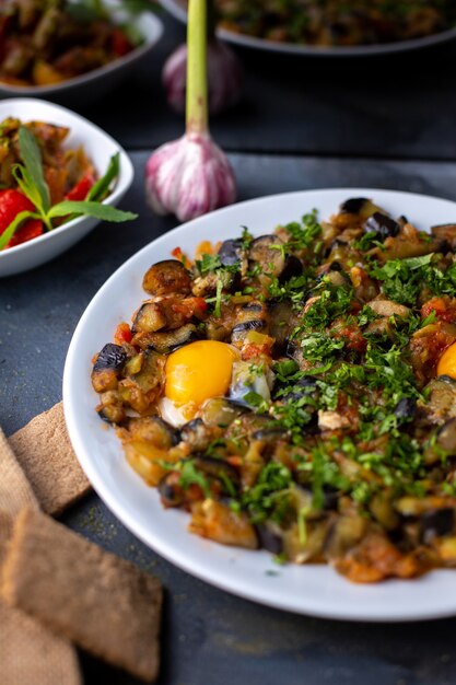 eggs vegetables cooked salted peppered along with bread loafs inside white plate