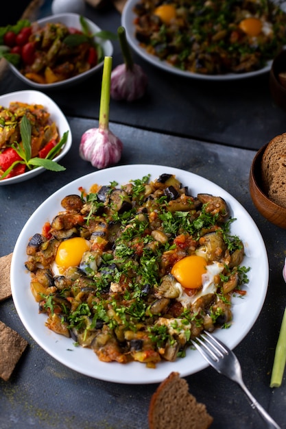 eggs vegetables cooked salted peppered along with bread loafs inside white plate