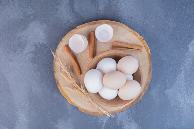 Eggs in a wooden cup on board.