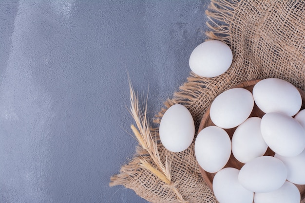 Eggs in a wooden platter on a piece of burlap