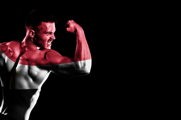 Egypt flag on handsome young muscular man black background