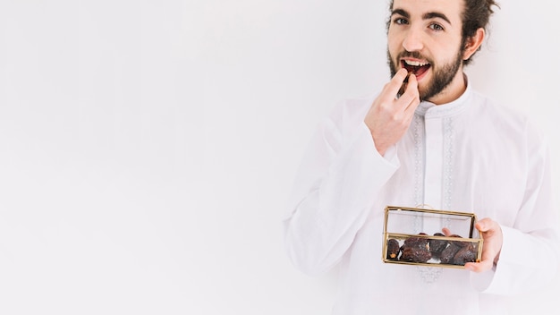 Eid al-fitr concept with man holding box of dates