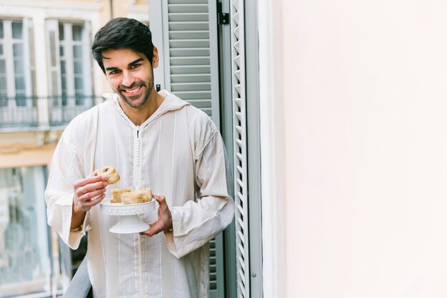 Free photo eid al-fitr concept with muslim man eating