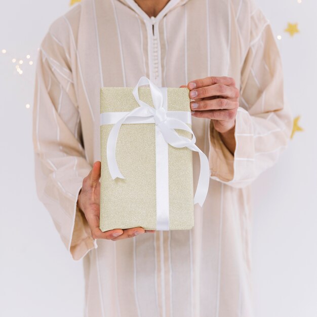 Eid al-fitr concept with muslim man holding present boxes