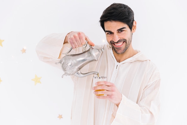 Free photo eid al-fitr concept with muslim man pouring tea