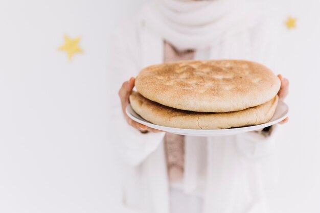 Eid al-fitr concept with woman holding bread