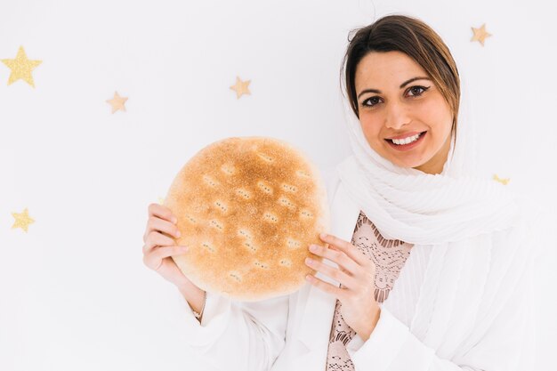 Eid al-fitr concept with woman holding bread