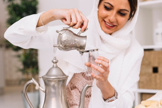 Концепция Ид аль-Фитр с женщиной, наливающей чай