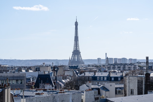 フランスのパリの太陽の下で建物に囲まれたエッフェル塔