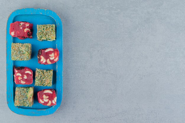 大理石の背景にあるトレイの2つのトルコ菓子の8つの喜び。高品質の写真