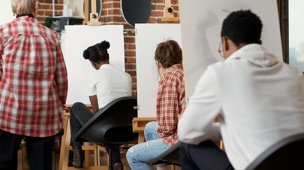 Free photo elder artist helping young student with vase model drawing in creative workshop, attending art class to develop new artistic skills. creating contemporary artwork for personal growth.