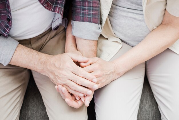 Elder couple holding their hands