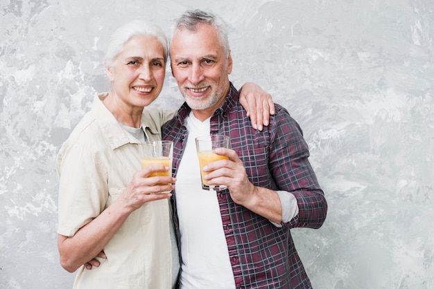 Elder couple posing with juice