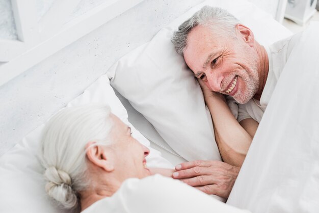 Пожилая пара отдыхает в постели